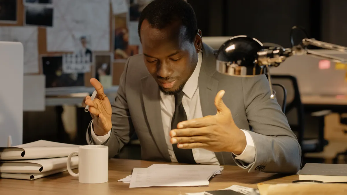 Professional reviewing verification documents at an office desk