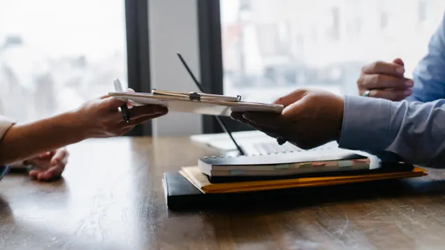 Candidate handing a resume to a recruitment professional